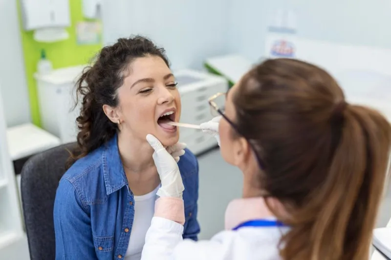Otolaryngologist examining a patient's throat during a swallowing evaluation